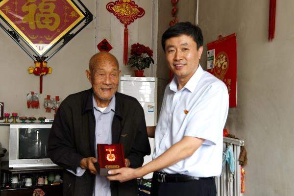 图一：慰问组人员向倪修田老人颁发“庆祝中华人民共和国成立70周年纪念章”_副本